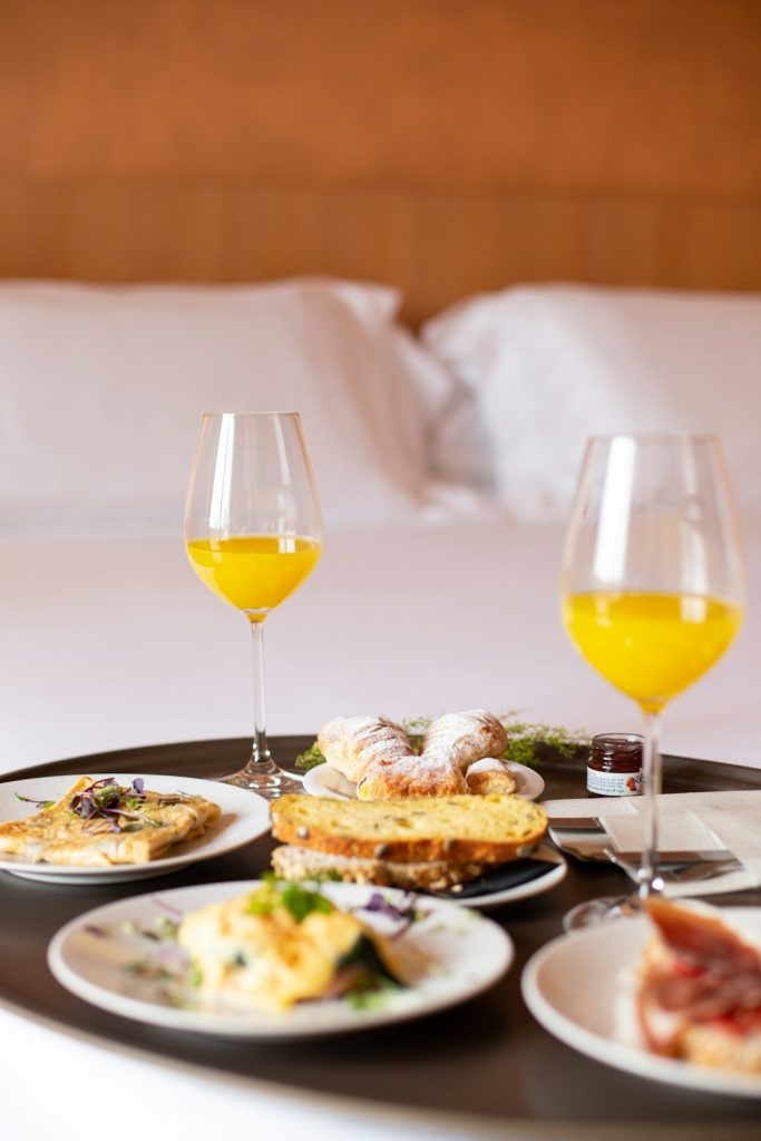 zipwp-image-lw3lqe2k7xc Breakfast in bed with orange juice and pastries.